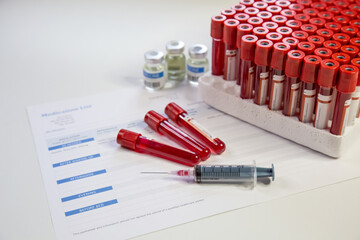 Injection syringe with blood sample vials and vaccine bottles and medication list for patients