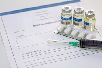 Injection syringe with vaccine bottles and tablets along with patient medication list on white background