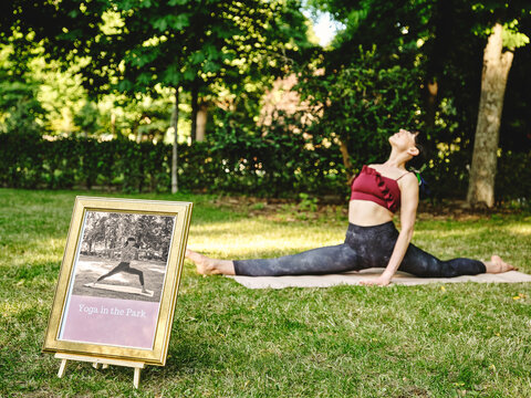 Full body side view of flexible female yoga trainer performing splits or Monkey pose during yoga session on green grass in summer park