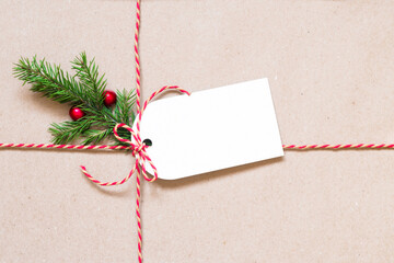 Gift tag and fir branch on brown paper. Christmas and New Year background with copy space