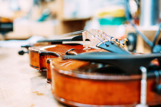 Modern shiny violin placed on shabby table in bright store with musical instruments