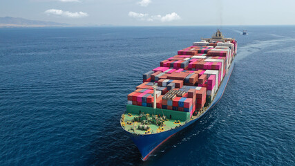 Aerial drone photo of industrial container tanker ship loaded with colourful truck size containers...
