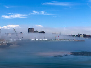 Saint John New Brunswick in low fog along the port with sunny skies