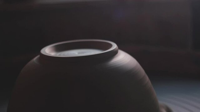 Female potter makes a pot on the pottery wheel. Potter at work, close up. Handmade, craft. White clay