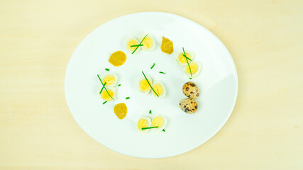 boiled quail eggs with mustard and chives on a plate