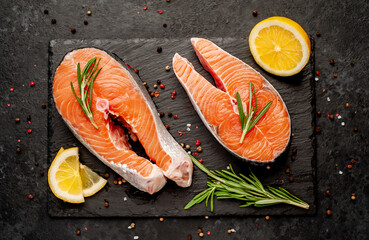 Raw fish salmon steak with lemon and rosemary on a stone background