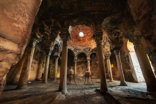 Low angle of interior of aged Arab Baths with tall stone columns and arched passages in Mallorca