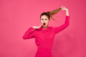 Portrait of a red-haired woman in bright clothes on a pink background cropped view of gesturing with her hands