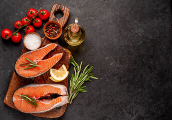 Raw fish salmon steak with lemon and rosemary on a stone background	