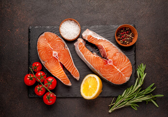 Raw fish salmon steak with lemon and rosemary on a stone background	