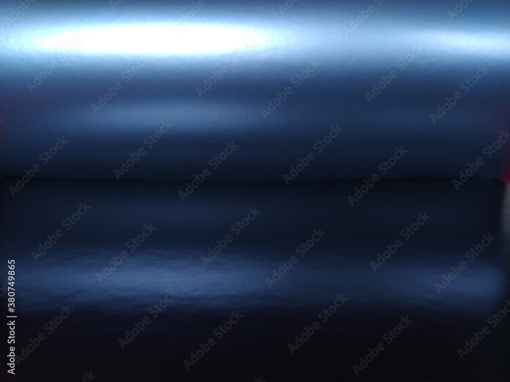 Poster gradient on a blue background. horizontally folded shiny paper or foil with overflow and highlights.
