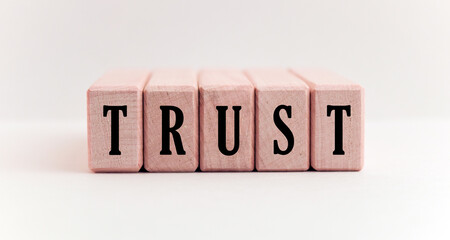 Concept word forming on wooden cube on white background - trust