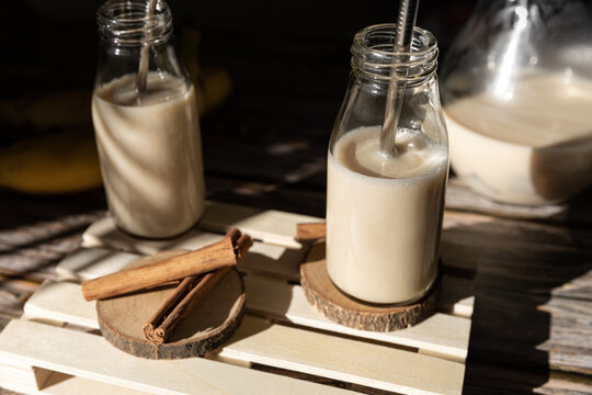 From above glass jar with healthy banana and cinnamon milkshake served on wooden table with ingredients