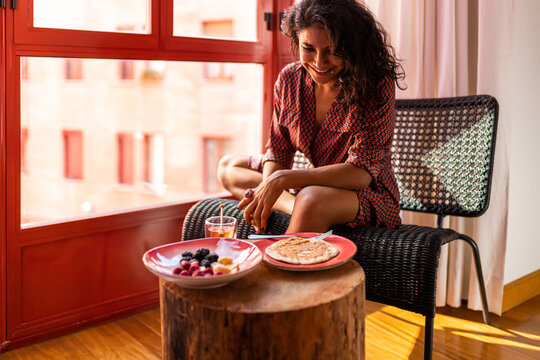 Ethnic Latin Woman Eating Healthy Breakfast Almond Flour Pancakes With Berries And Honey