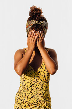 Woman covering her face with hands while standing outdoors