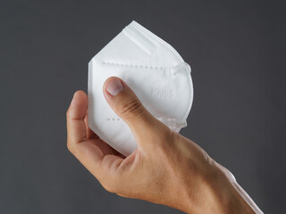 Close-up. Hand holding a white face protective mask FFP2..
