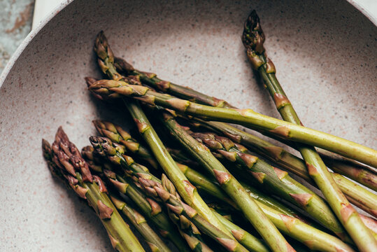 Raw Organic Asparagus Spears, on rustic surface