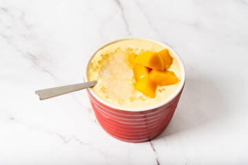 A bowl of sago with mango and coconut milk 