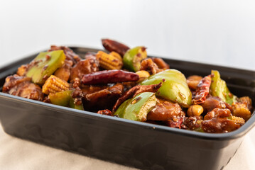 Large bowl of Kung Pao chicken shows the sheen of spicy sauce and meat