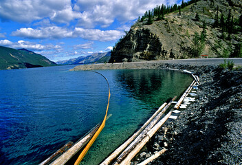 Oil containment boom and absorbent paper minimize environmental damage from diesel fuel spill to fresh water Muncho Lake, British Columbia, Canada  © John Nakata