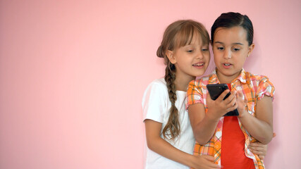 people, children, technology, friends and friendship concept - happy little girls with smartphones lying on floor at home