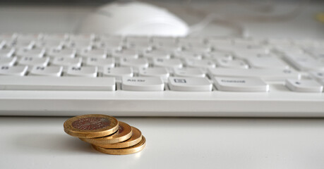 Closeup shot of a computer keyword and coins