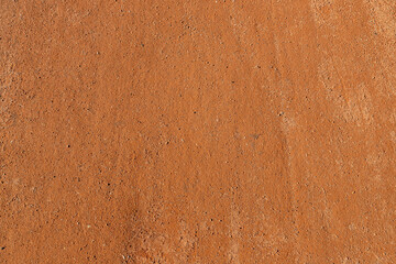 Texture of orange gravel surface with fine particles for filling paths in parks.