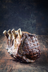 Traditional barbecue dry aged angus cote de boeuf with spice offered as close-up on a rustic board