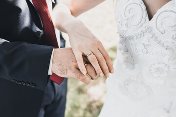 man and woman holding hands. wedding rings bride and groom on the background. Wedding ceremony. Jewelry.