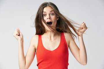 Surprised woman open mouth holds hands in front of her Red T-shirt 