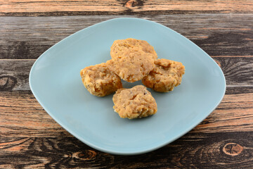 Caramel and shredded coconut clusters on blue snack plate on table