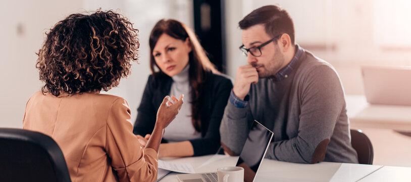 Couple Consulting With A Female Financial Manager At The Bank