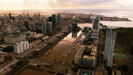 Aerial view of the Puerto Madero promenade with the Women's Bridge, Buenos Aires, Argentina.Sunset with sun rays and business buildings.