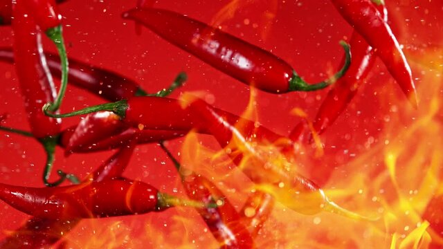 Super Slow Motion Shot of Flying Red Chilli Peppers with Fire Flames in the Air at 1000fps.