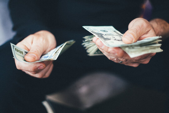 Man's hands holding and counting cash
