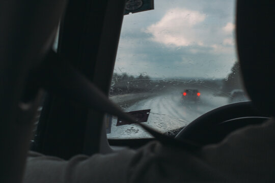 A person driving a car in a rainy day