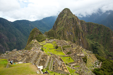Aa wide angle view of Macchu Picchu with tourists in the foreground, Peru.