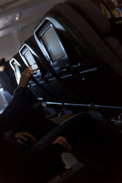 Person's hand touching in-flight entertainment screen