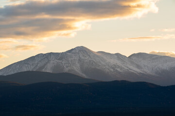 Fototapeta premium Hazy fall afternoon sunset shot in Yukon Territory, northern Canada taken in the fall/autumn time of year with a huge mountains in the shot and snow capped peaks in the distance. 
