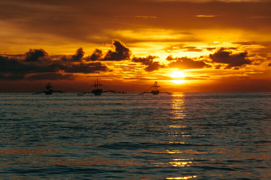 Three traditional boats on the sea at sunset