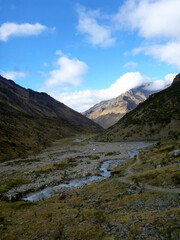 A scenic view of the rocky and mountainous terrain along the Salkantay trek in Peru, with a river in the foreground