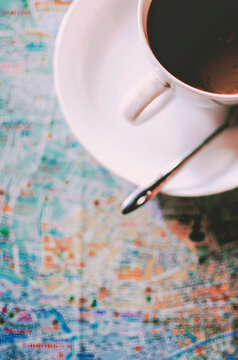 White cup of black coffee on the map