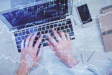 Double exposure of woman hands working on computer and forex chart hologram drawing. Top View. Financial analysis concept.