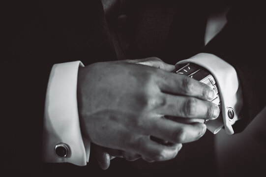 Closeup of dressed up man's hands checking the time on his watch