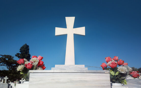 white cross on the grave and blue sky