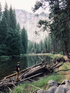 Man walks on a log next to Yosemite river