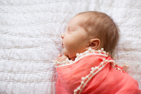 Closeup profile of a newborn baby swaddled