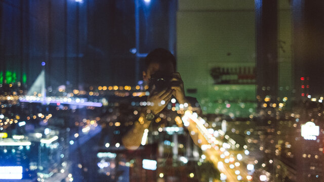 Self portrait of a photographer with city panorama out of focus