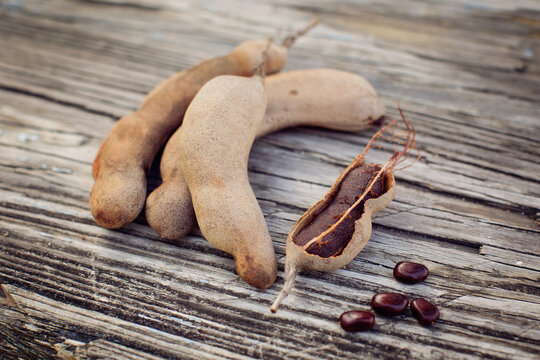Tamarind fruit on a textured bench