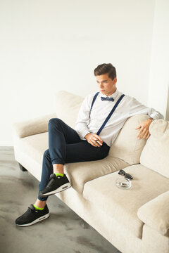 Modern businessman with stylish outfit sitting on luxury sofa.